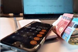 Denaro e smartphone su scrivania