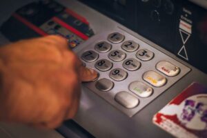 Persona che digita codice pin all'ATM