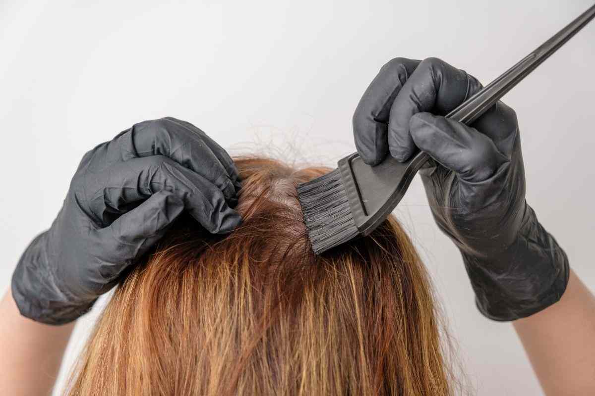 donna che applica tintura ai capelli