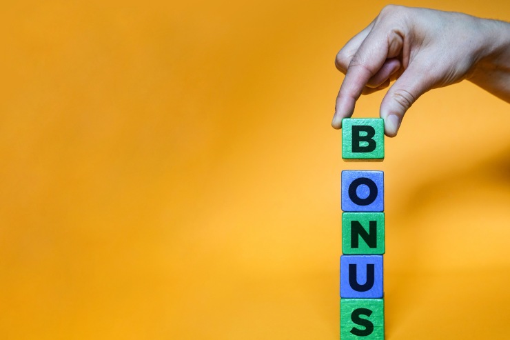 mano tiene scritta a domino bonus su sfondo giallo