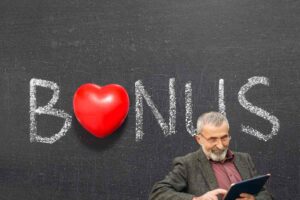 lavagna con scritta bonus e disegno cuore e uomo che guarda sorridente il tablet