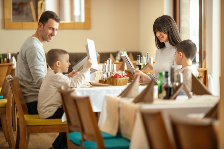 famiglia a tavola in albergo legge il menù
