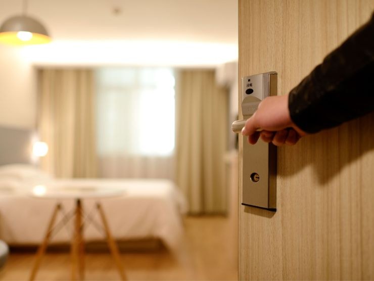 persona che apre porta di camera da letto