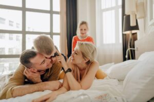 famiglia felice in stanza d'albergo mamma papà figlia e figlio