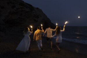 Ragazzi sulla spiaggia di notte con delle torce