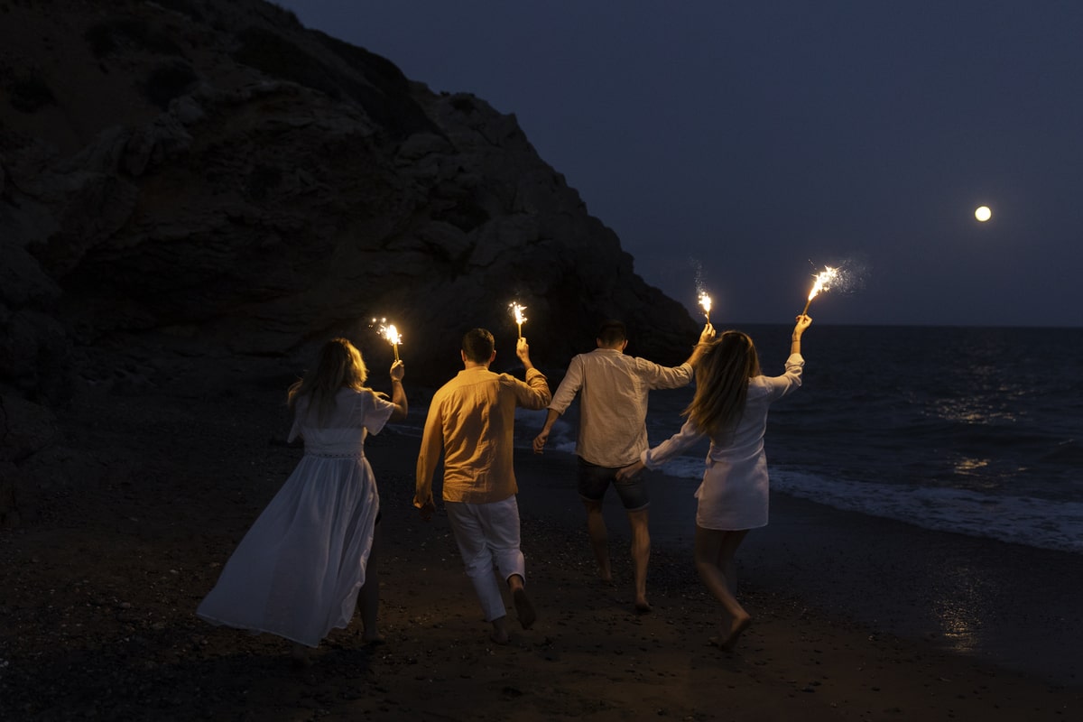 Ragazzi sulla spiaggia di notte con delle torce